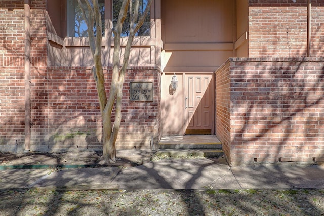 doorway to property featuring brick siding