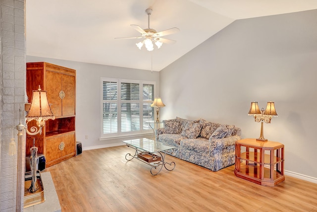 living area with lofted ceiling, light wood finished floors, a ceiling fan, and baseboards