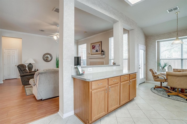 kitchen featuring visible vents, open floor plan, hanging light fixtures, light countertops, and crown molding