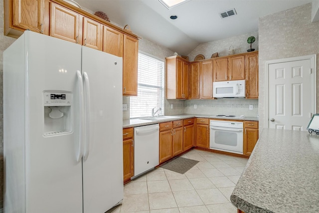 kitchen with white appliances, visible vents, vaulted ceiling, light countertops, and a sink