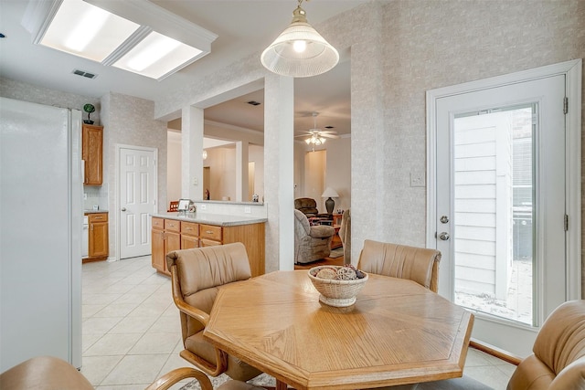 dining space with light tile patterned floors, ceiling fan, visible vents, baseboards, and wallpapered walls