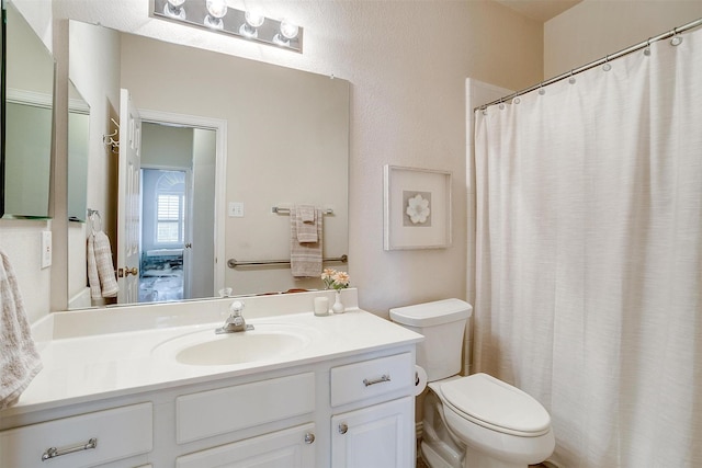 ensuite bathroom with toilet, connected bathroom, and vanity