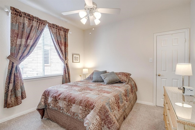 bedroom featuring baseboards, a ceiling fan, and light colored carpet