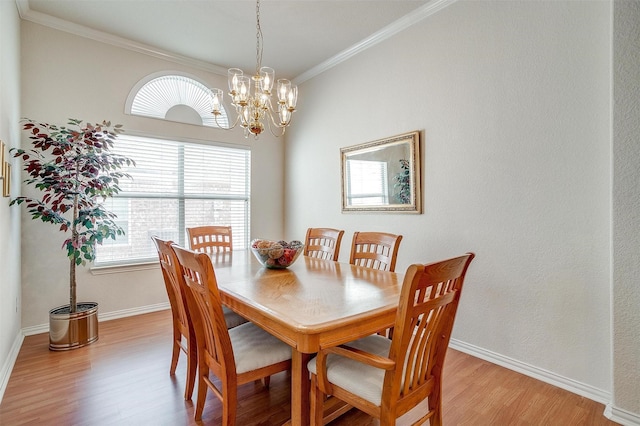 dining area with a notable chandelier, light wood-style flooring, baseboards, and crown molding