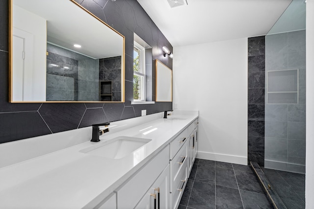 bathroom with double vanity, a sink, baseboards, and a walk in shower