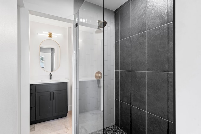 full bathroom with marble finish floor, vanity, and walk in shower