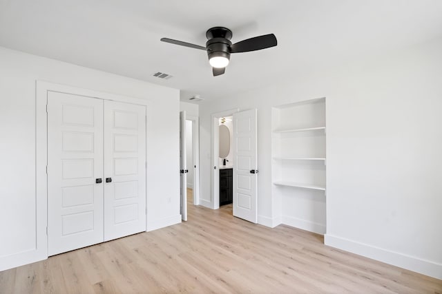 unfurnished bedroom featuring light wood finished floors, visible vents, baseboards, ensuite bathroom, and a closet