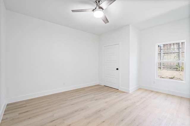 empty room with baseboards, ceiling fan, and light wood finished floors