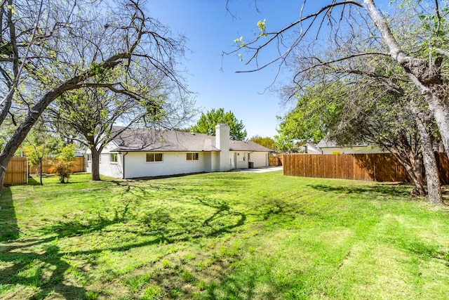 view of yard with an attached garage and fence