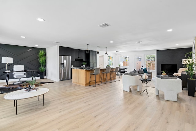 living area with recessed lighting, visible vents, and light wood-style floors