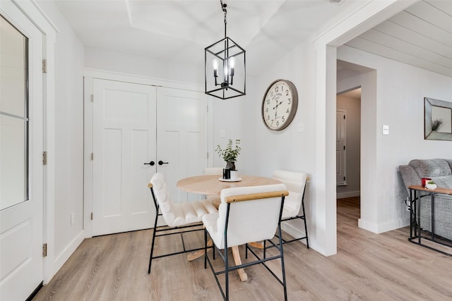 dining space with light wood-style floors, a chandelier, and baseboards