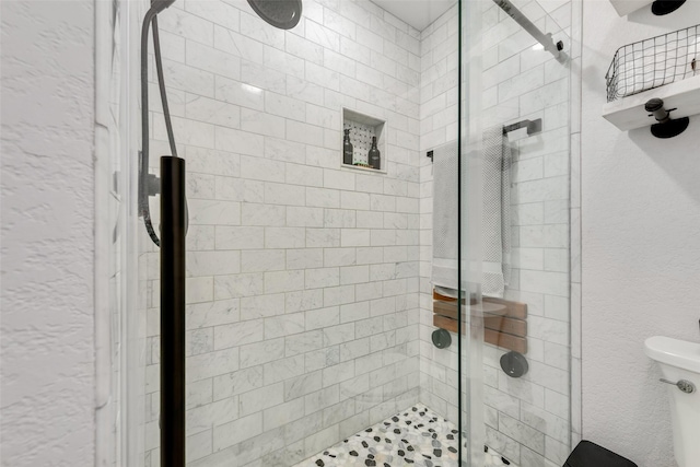 full bathroom featuring a stall shower, a textured wall, and toilet