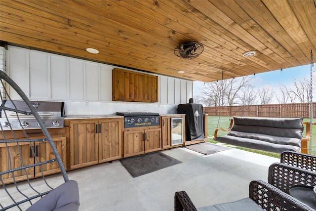 view of patio featuring exterior kitchen, grilling area, and fence