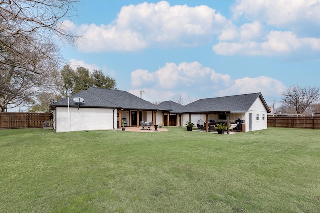 back of property with a yard, board and batten siding, and a patio