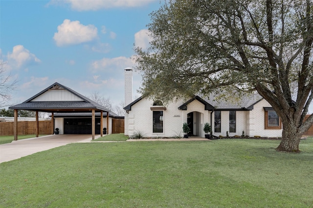 view of front of home with brick siding, fence, driveway, a carport, and a front lawn