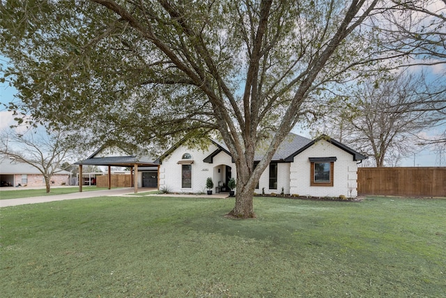 view of front of house with brick siding, fence, driveway, a carport, and a front lawn