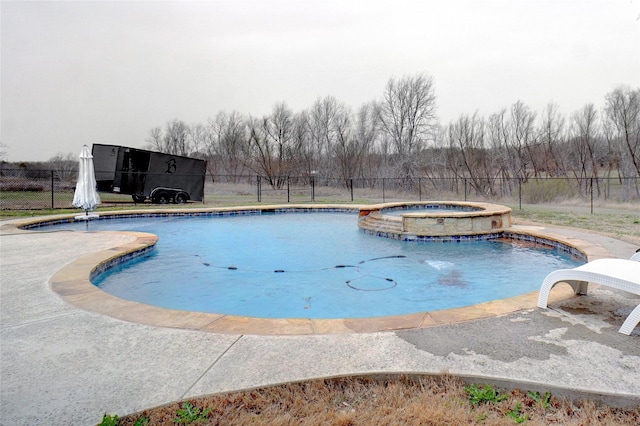 view of pool featuring a pool with connected hot tub, fence, and a water slide