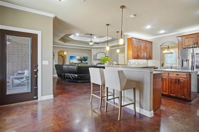 kitchen with tasteful backsplash, visible vents, arched walkways, a breakfast bar area, and finished concrete floors