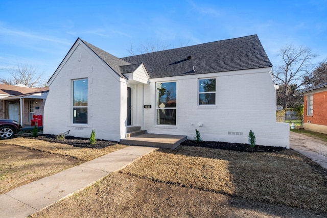 view of front of property with crawl space, a shingled roof, and brick siding