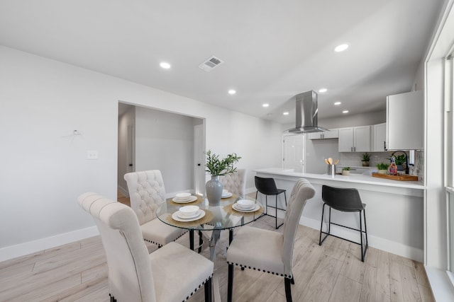 dining room featuring visible vents, baseboards, light wood-style flooring, and recessed lighting