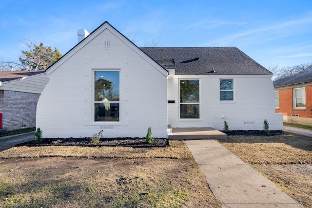 view of front of house with a shingled roof, crawl space, and brick siding