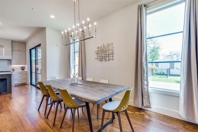 dining space with a healthy amount of sunlight, light wood-style flooring, and baseboards