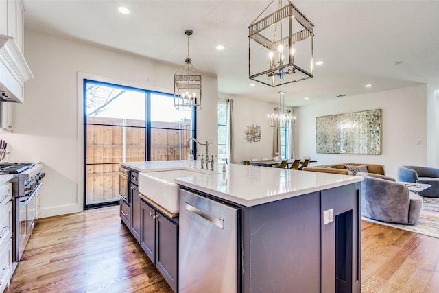 kitchen featuring recessed lighting, open floor plan, appliances with stainless steel finishes, ventilation hood, and an inviting chandelier