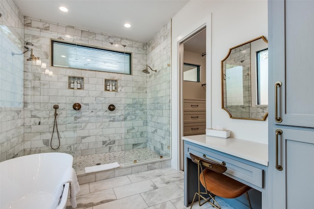 full bath featuring recessed lighting, vanity, a freestanding bath, marble finish floor, and a tile shower