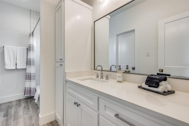 bathroom featuring vanity, baseboards, and wood finished floors