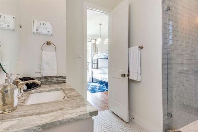 bathroom featuring a chandelier, a stall shower, vanity, and ensuite bath