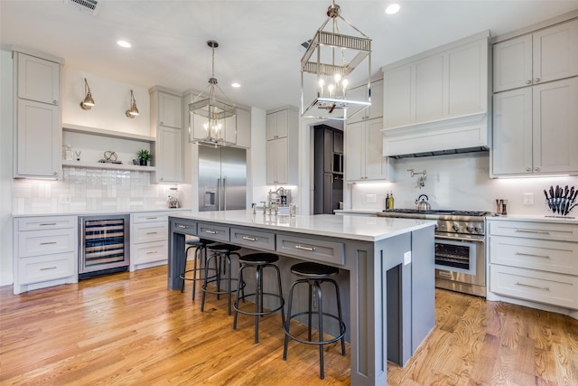 kitchen featuring beverage cooler, high quality appliances, light countertops, open shelves, and a notable chandelier