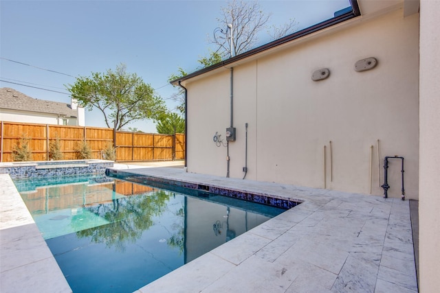 view of swimming pool with a pool with connected hot tub and fence