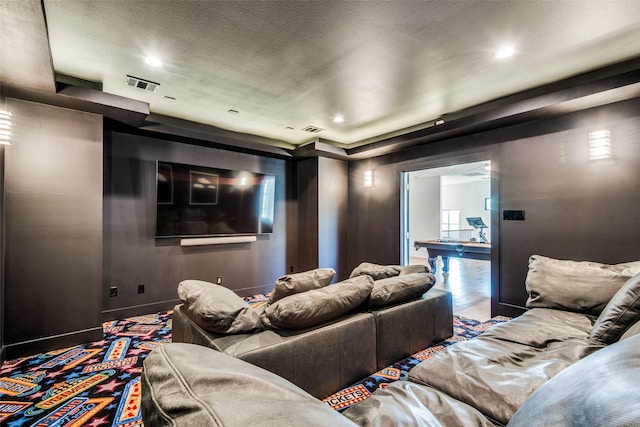 cinema room featuring recessed lighting, visible vents, a textured ceiling, and baseboards