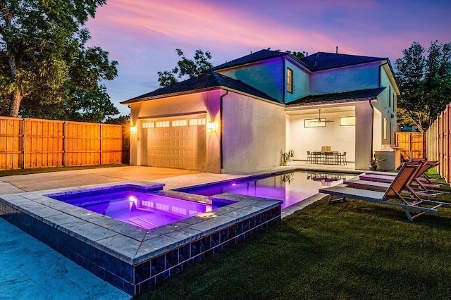 pool at dusk with a fenced in pool, a patio, a fenced backyard, an in ground hot tub, and a yard