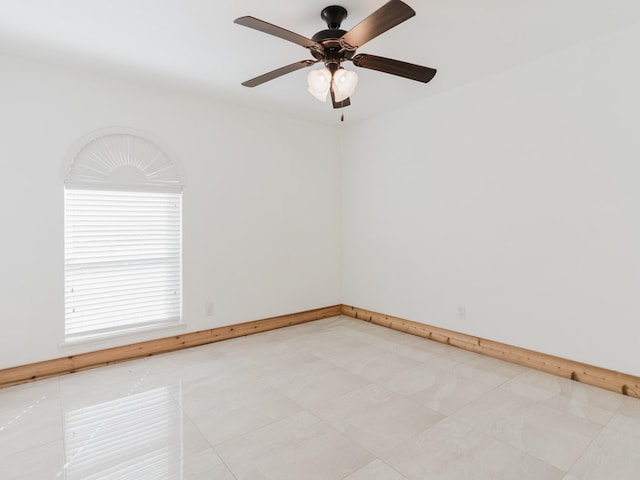 unfurnished room with baseboards and a ceiling fan