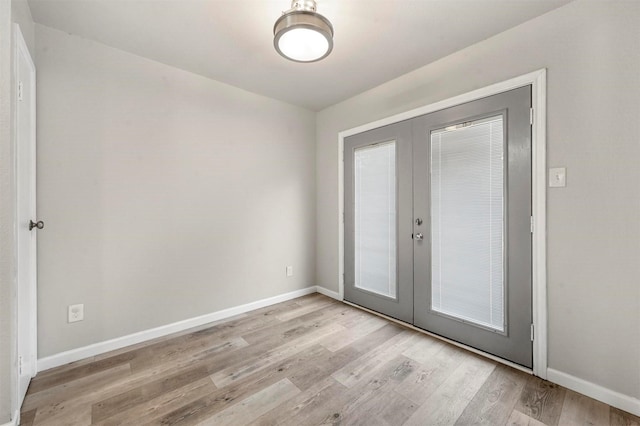 doorway featuring french doors, light wood-style flooring, and baseboards