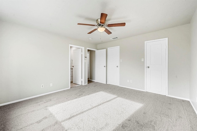 unfurnished bedroom with visible vents, baseboards, ceiling fan, ensuite bathroom, and carpet floors