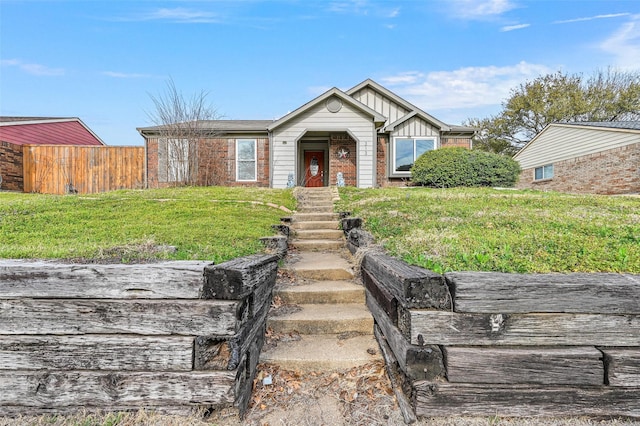 view of front of house featuring board and batten siding, brick siding, and fence