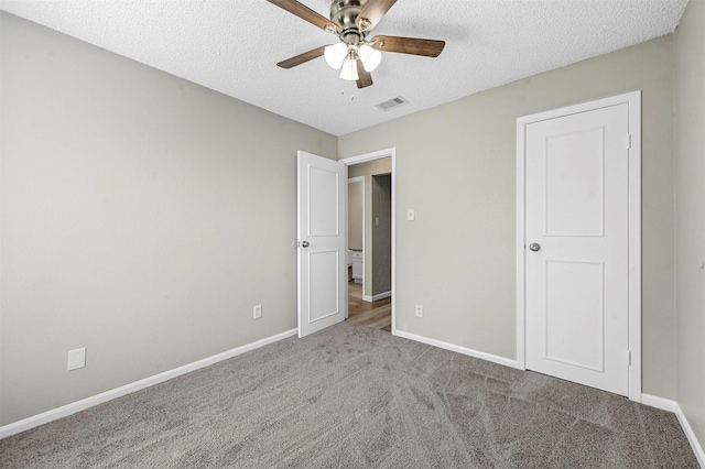 unfurnished bedroom featuring carpet, baseboards, visible vents, and a textured ceiling