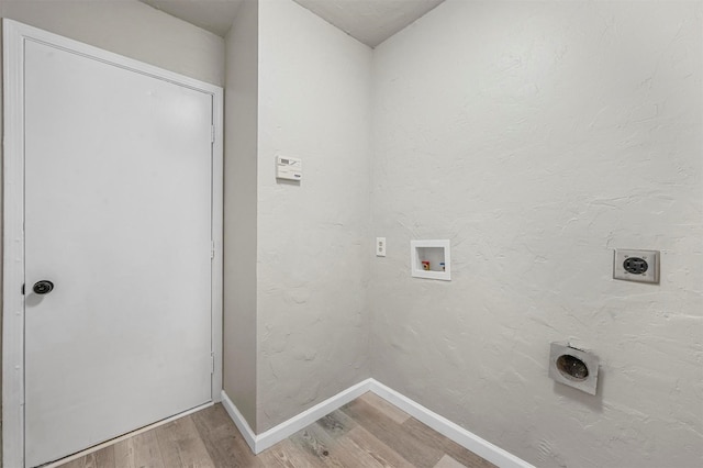 clothes washing area with light wood finished floors, hookup for a washing machine, electric dryer hookup, laundry area, and baseboards