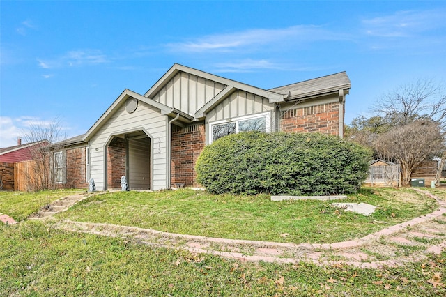 view of front of property featuring a garage, a front lawn, board and batten siding, and brick siding