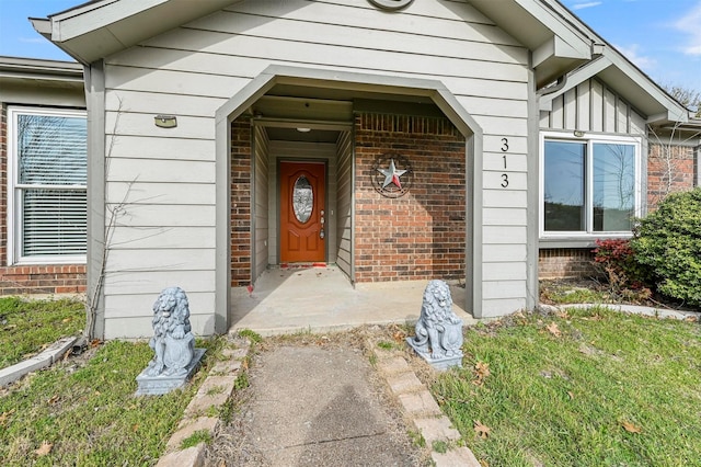 entrance to property with board and batten siding and brick siding