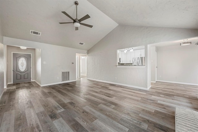 unfurnished living room with ceiling fan, wood finished floors, and visible vents