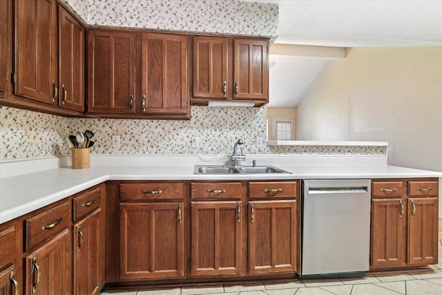 kitchen with light tile patterned floors, lofted ceiling, light countertops, stainless steel dishwasher, and a sink