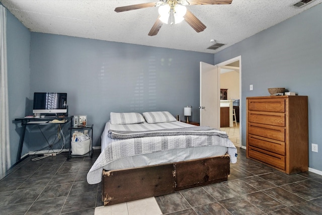 tiled bedroom with baseboards, ceiling fan, visible vents, and a textured ceiling