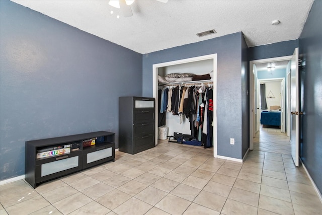 bedroom with a closet, visible vents, baseboards, and light tile patterned floors