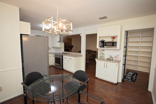 dining space with dark wood-style flooring, wainscoting, visible vents, and an inviting chandelier