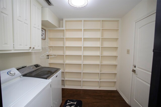 washroom featuring dark wood-type flooring, washer and dryer, visible vents, and cabinet space