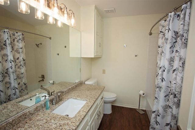 bathroom with toilet, shower / tub combo, wood finished floors, vanity, and visible vents