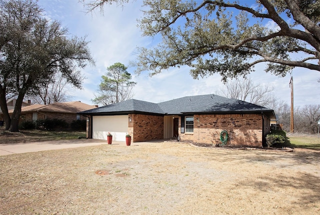 single story home with a garage, roof with shingles, concrete driveway, and brick siding